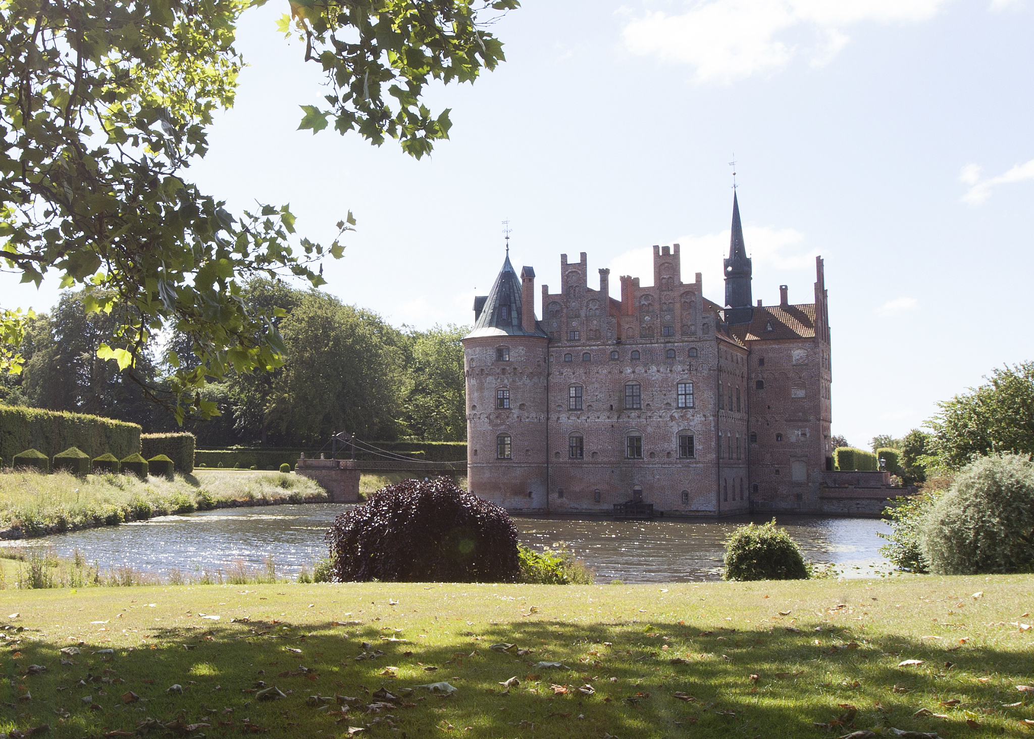 Egeskov Slot spiegelt sich malerisch im Wassergraben – ein echtes Märchenschloss inmitten grüner Parklandschaft auf Fyn.