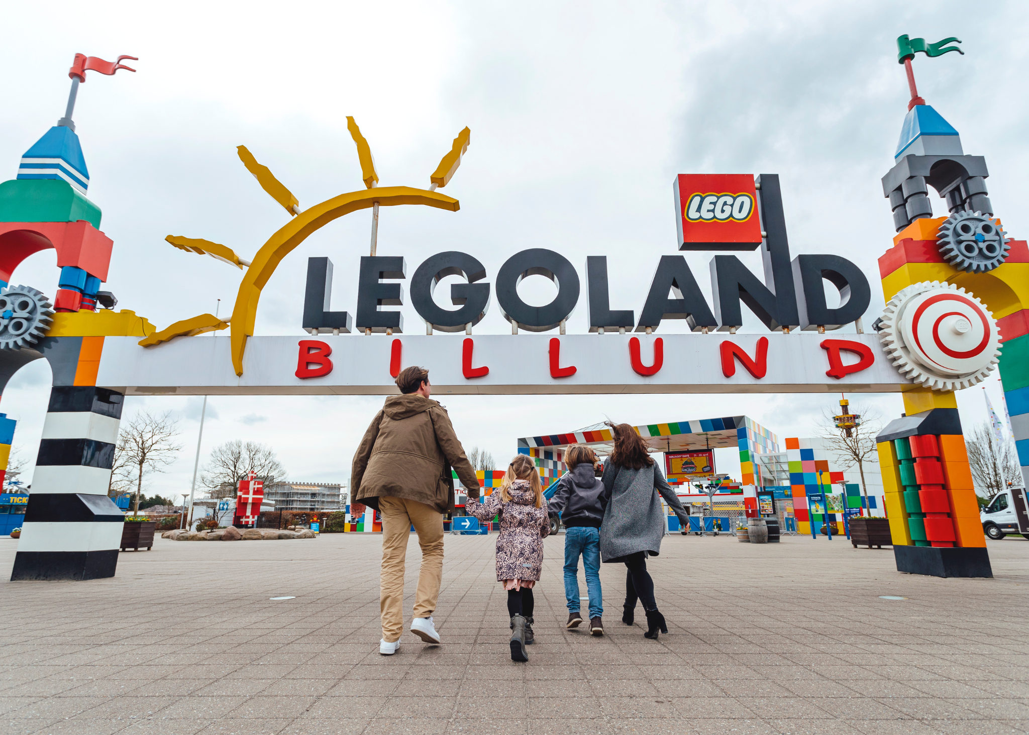 Die ganze Familie strahlt, denn jetzt geht's ins bunte Legoland-Abenteuer!