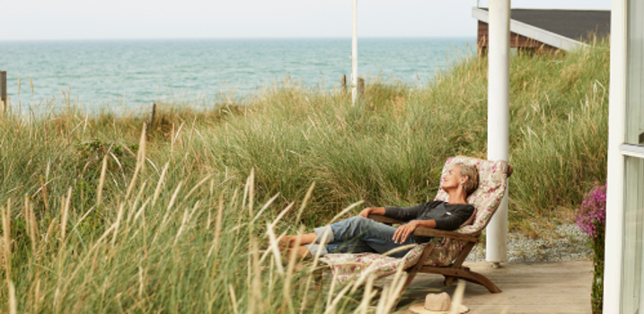 sommerhusferie med kvinde i liggestol på terrassen